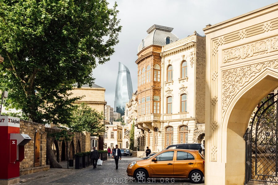 A historic view of Baku Old City with the modern Flame Towers in the distance.