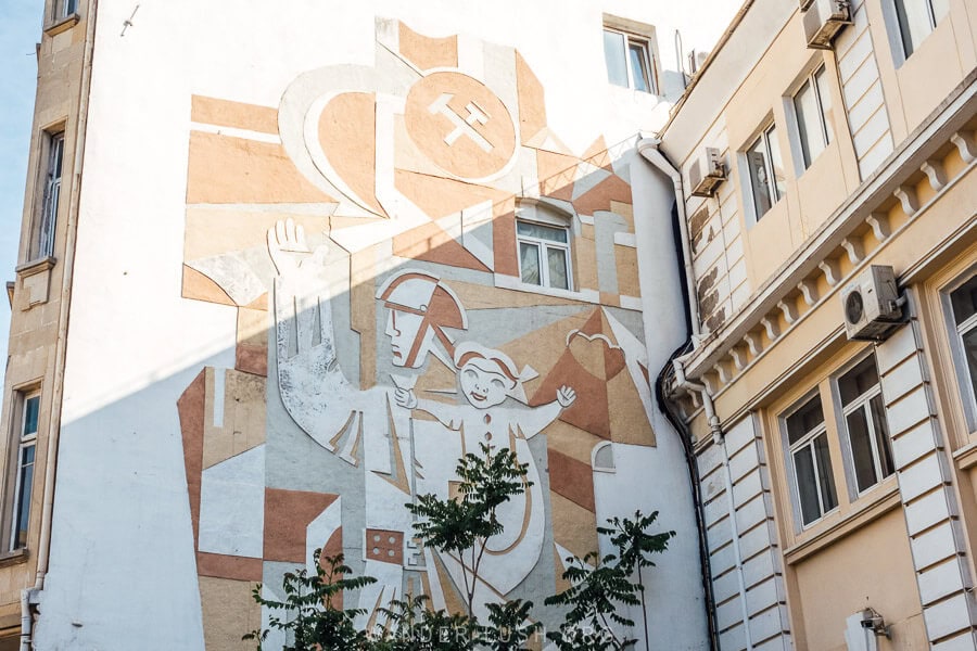 A Soviet-style sculpture on a wall in Baku showing a soldier carrying a child on his shoulder.