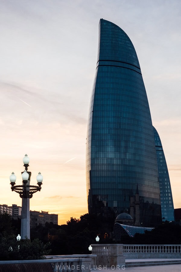 Baku Flame Towers silhouetted against a sunset sky.
