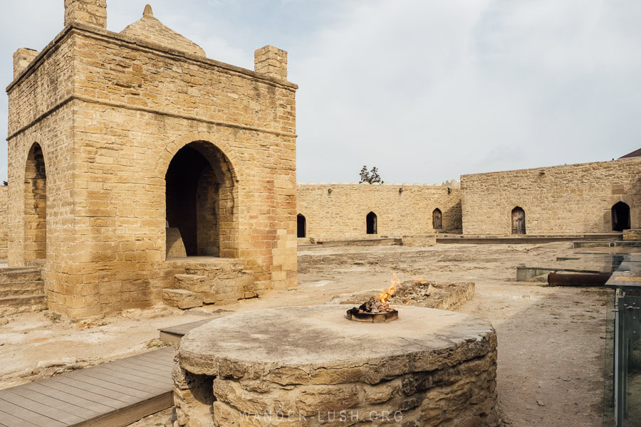 Ateshgah, an ancient stone temple with a burning flame on a pedestal.