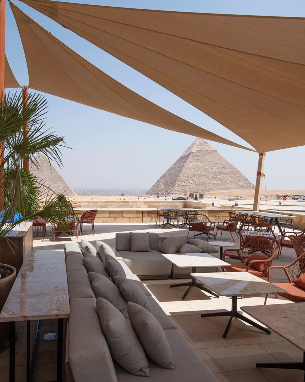 The elegant Khufu's restaurant in Giza has soft reclining couches and a long table with the pyramids in the background.