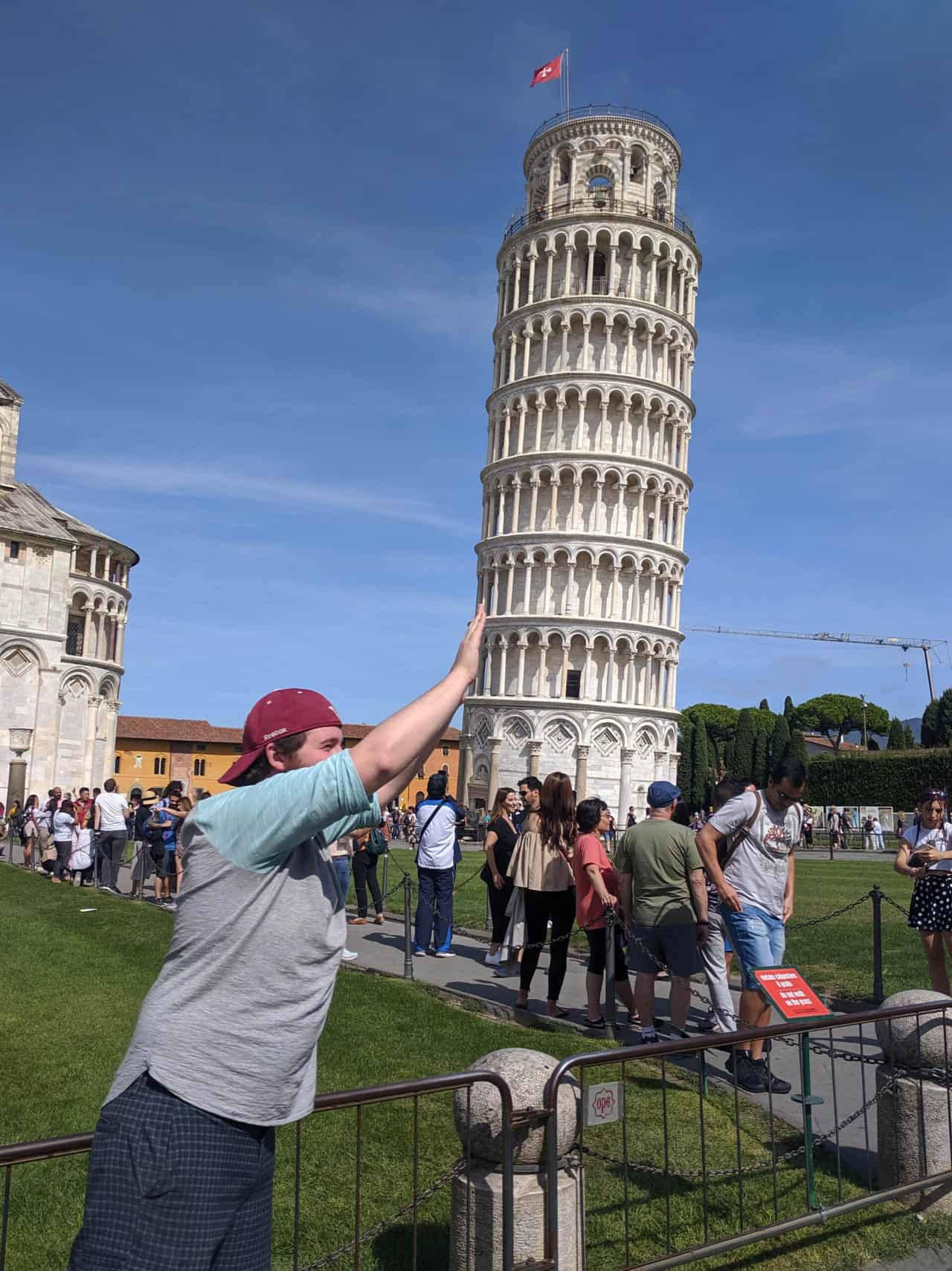 Colin adopting the typical tourist pose of pushing the tower at the Leaning Tower of Pisa in Italy