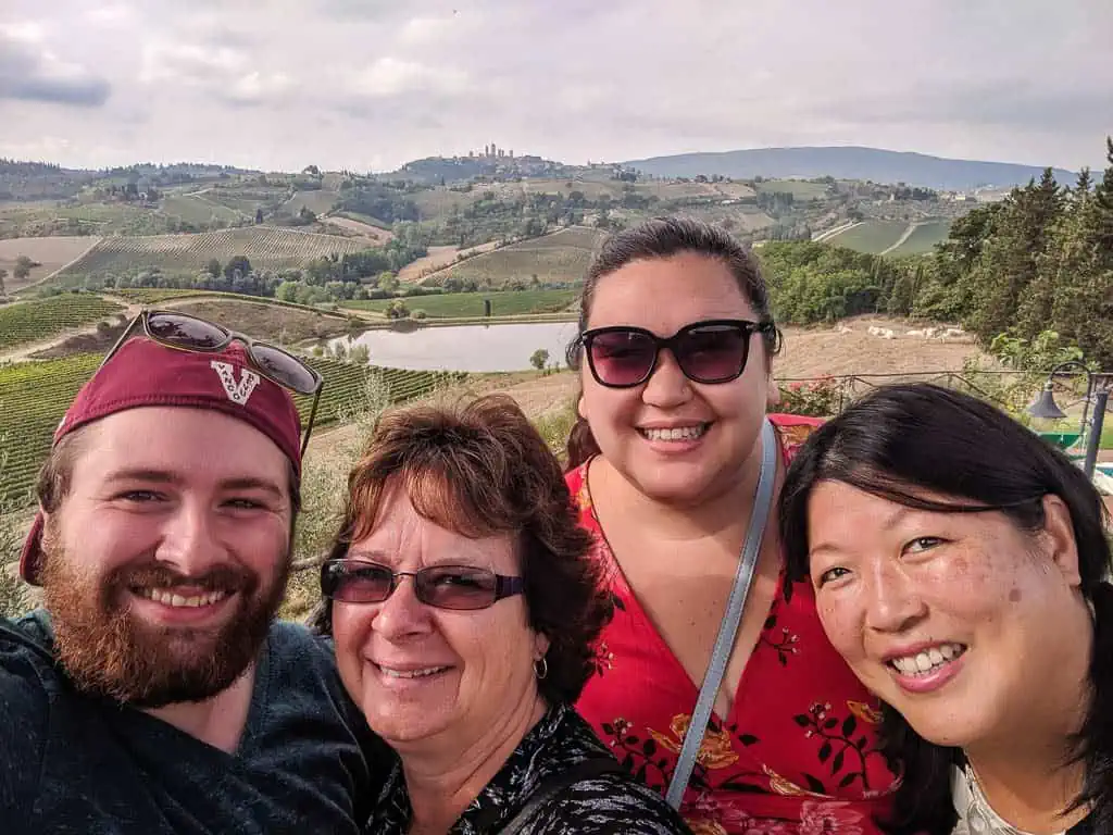 selfie of Riana and Colin with their moms with view of San Gimignano