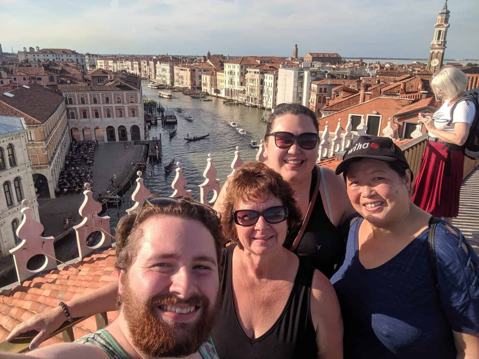 Selfie of Riana, Colin and their moms on a rooftop in Venice from our moms trip in europe, venice, italy