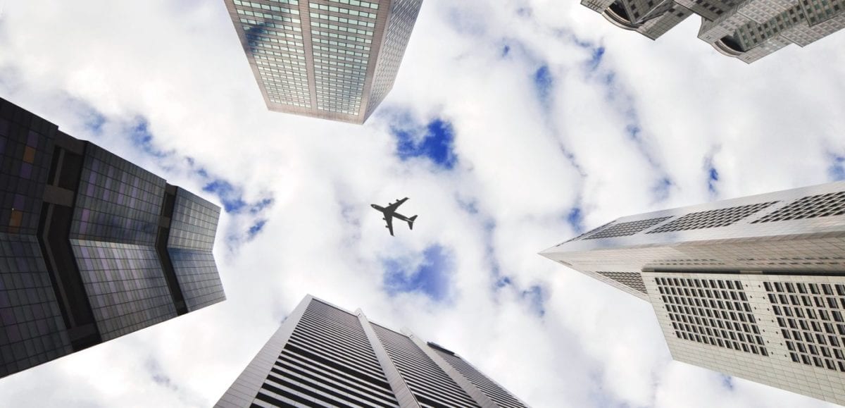 plane in the sky with buildings