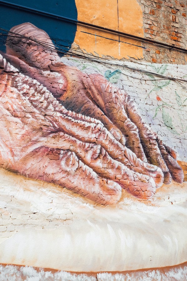 Close up details of street art in Kutaisi showing a woman preparing khachapuri.