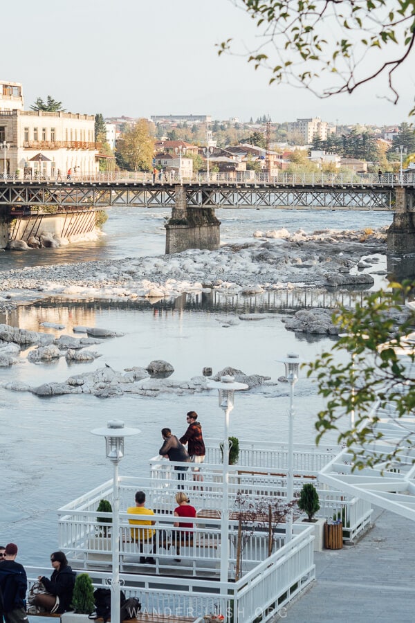People standing on a viewpoint overlooking the White Bridge in Kutaisi.