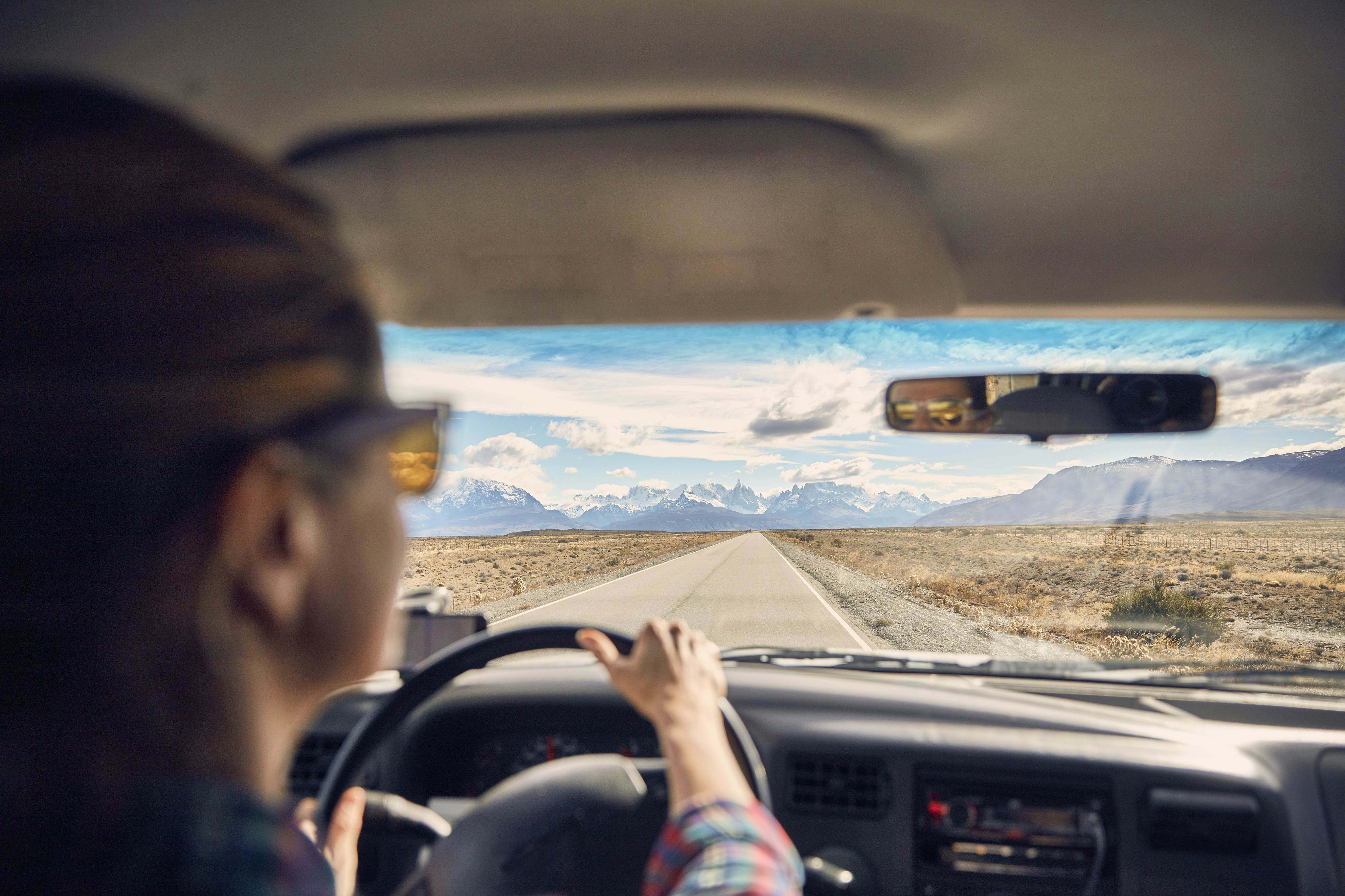 Woman driving camper on the road towards Fitz Roy and Cerro Torre, El Chalten, Patagonia, Argentina 