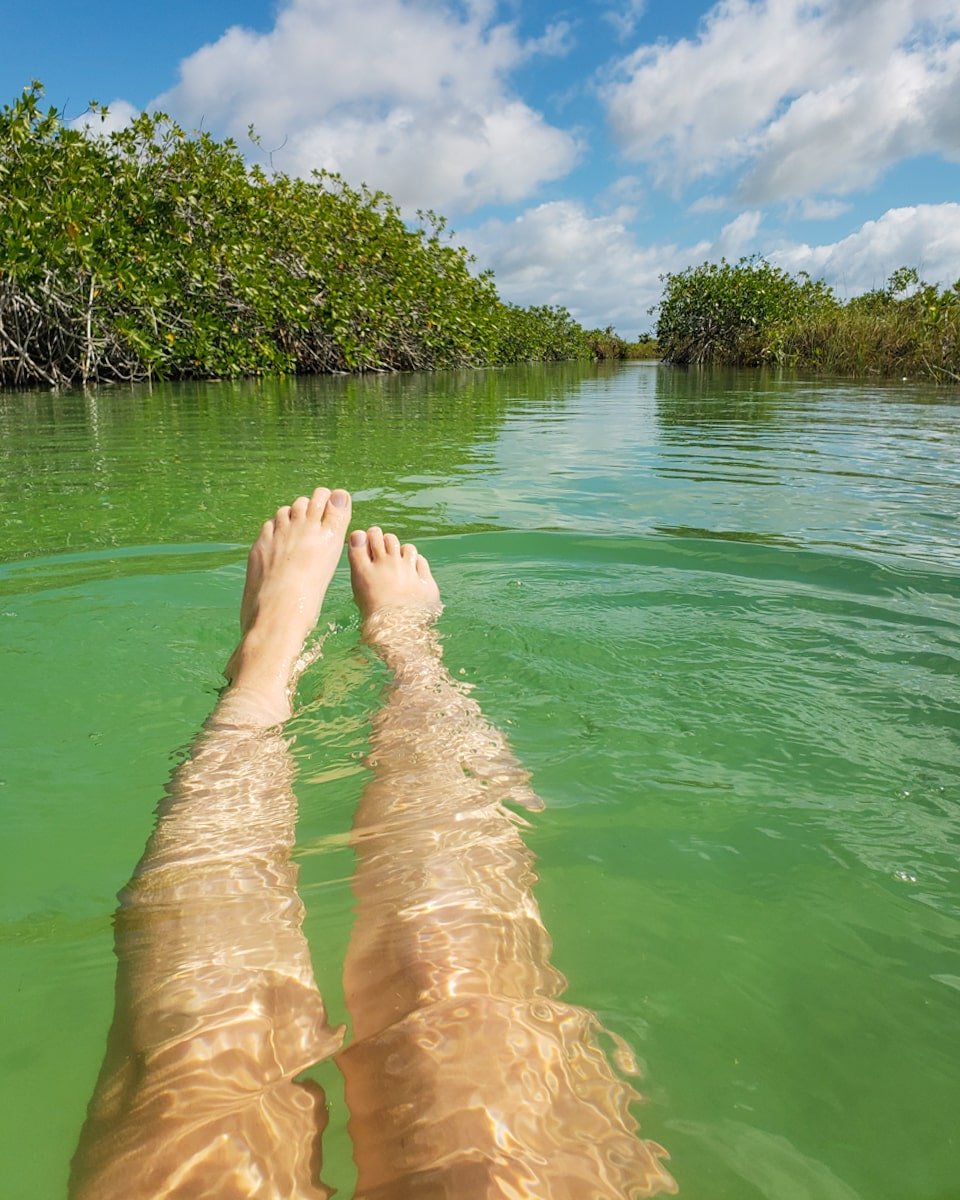 Female traveler floating down Muyil river float inside the Sian Ka'an canals and lagoon near Tulum, Mexico.