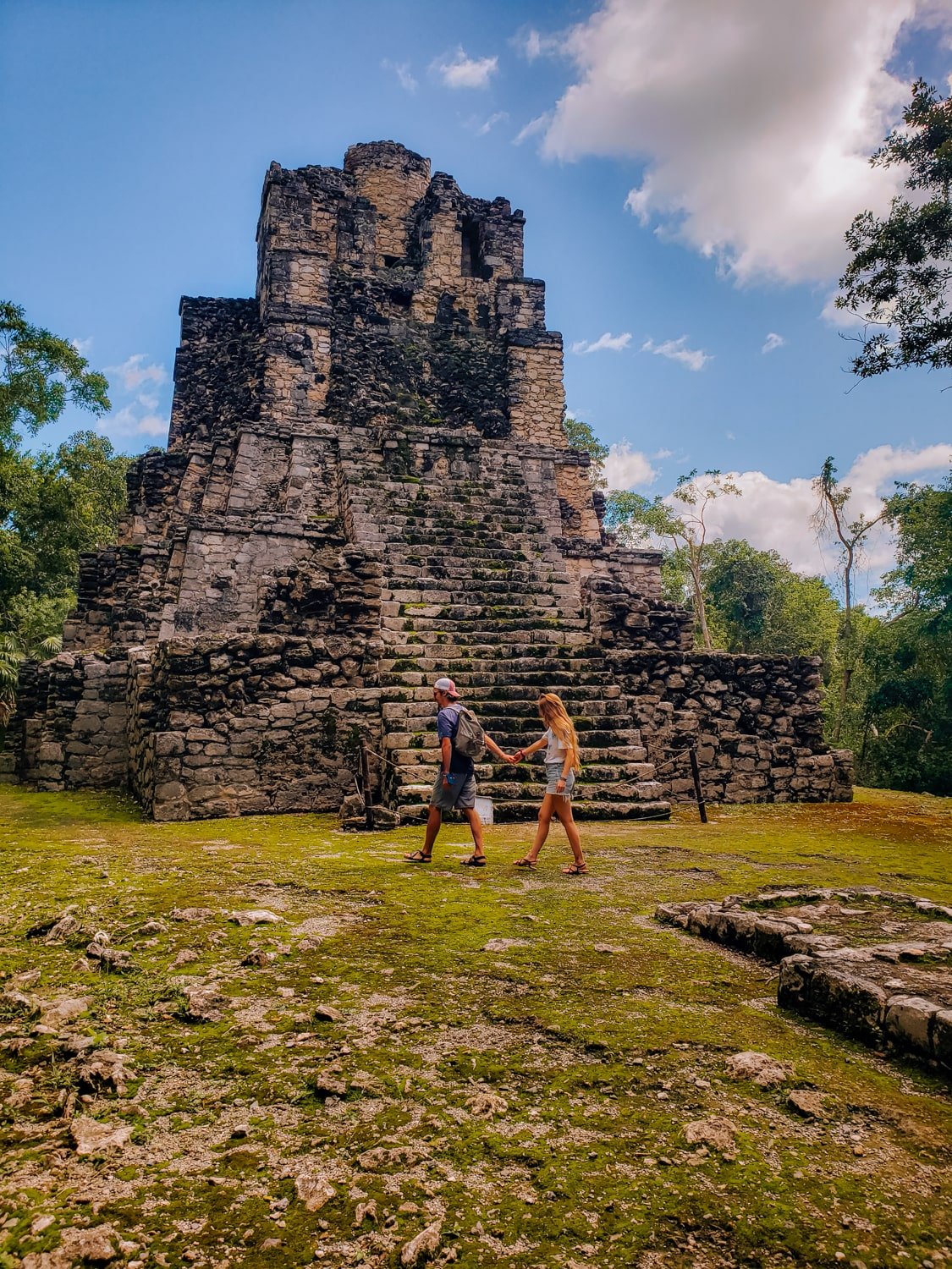 A travel couple in front of Muyil mayan ruins near Tulum, Mexico.