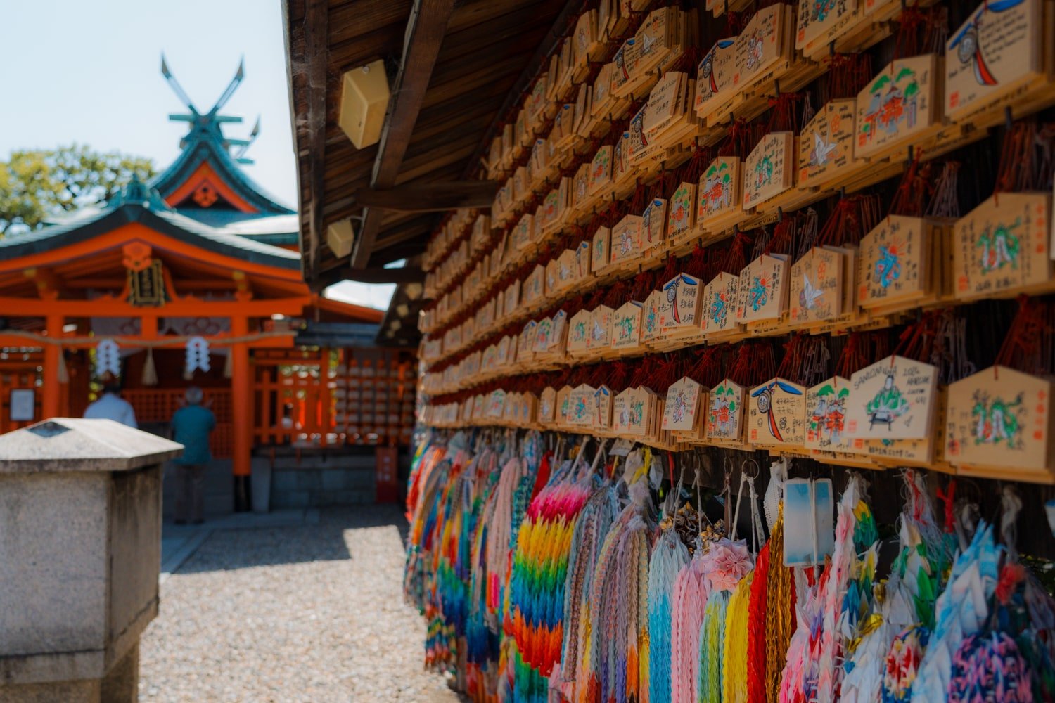 Fushimi Inari shrine main buildings with prayer plaques and colorful strings.