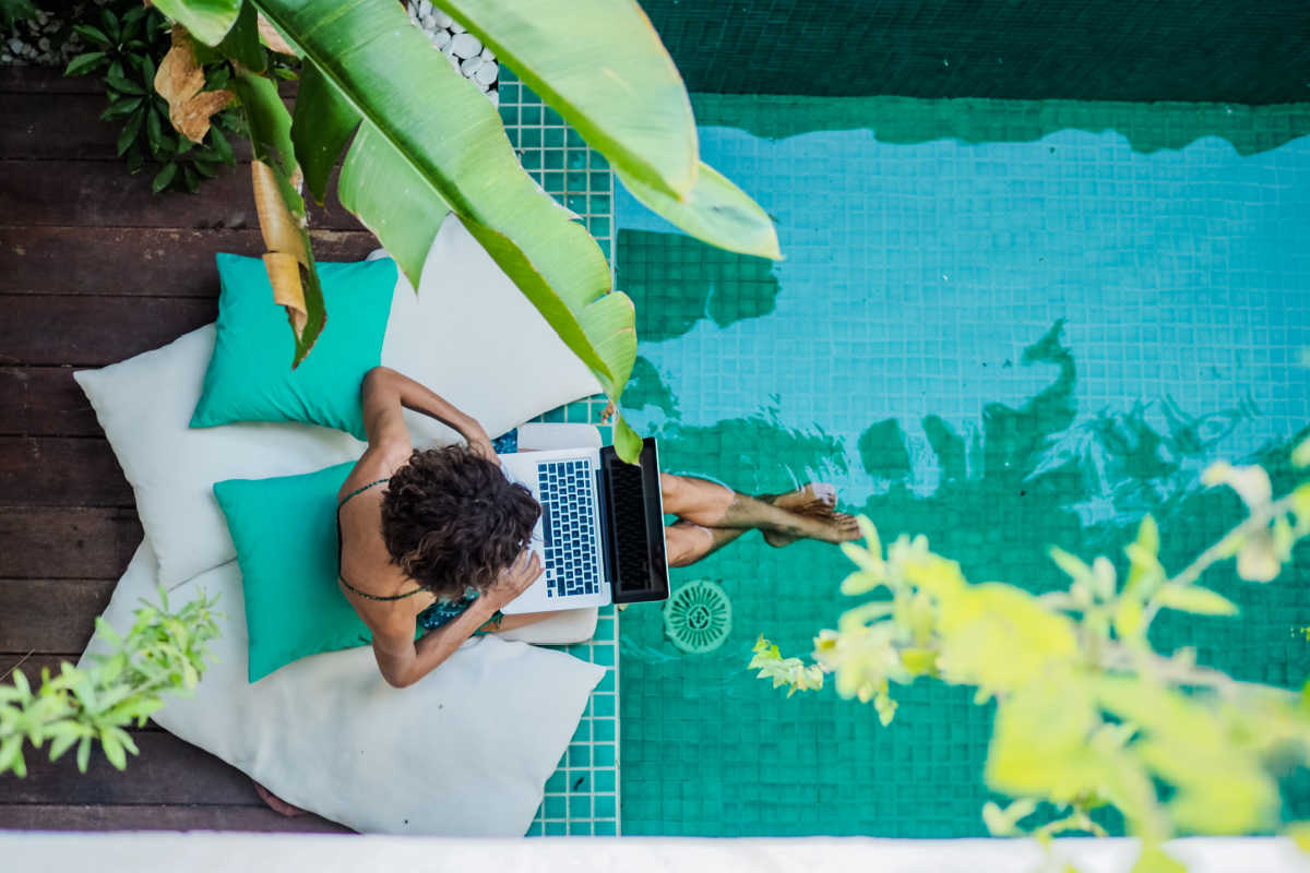 Digital Nomad Works on Laptop By Pool.jpg