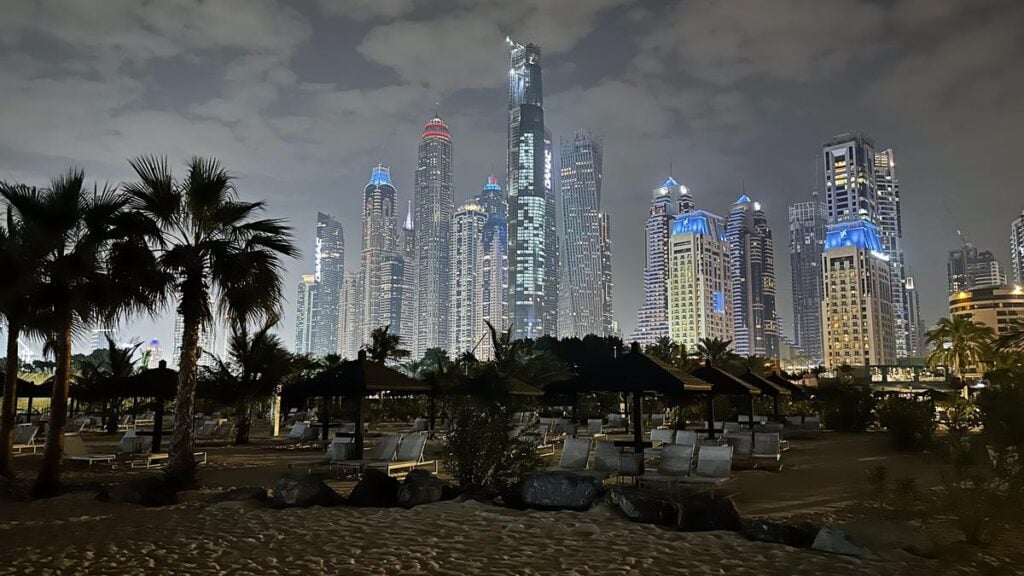 Stunning night view of JBR Beach with Dubai Marina skyline illuminated - urban luxury and tranquility.