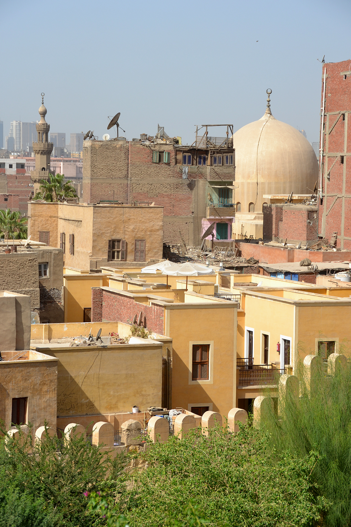 The Ayyubid Wall in Cairo's Azhar Park rises up overlooking a cluster of residential homes, minarets and a dome. 