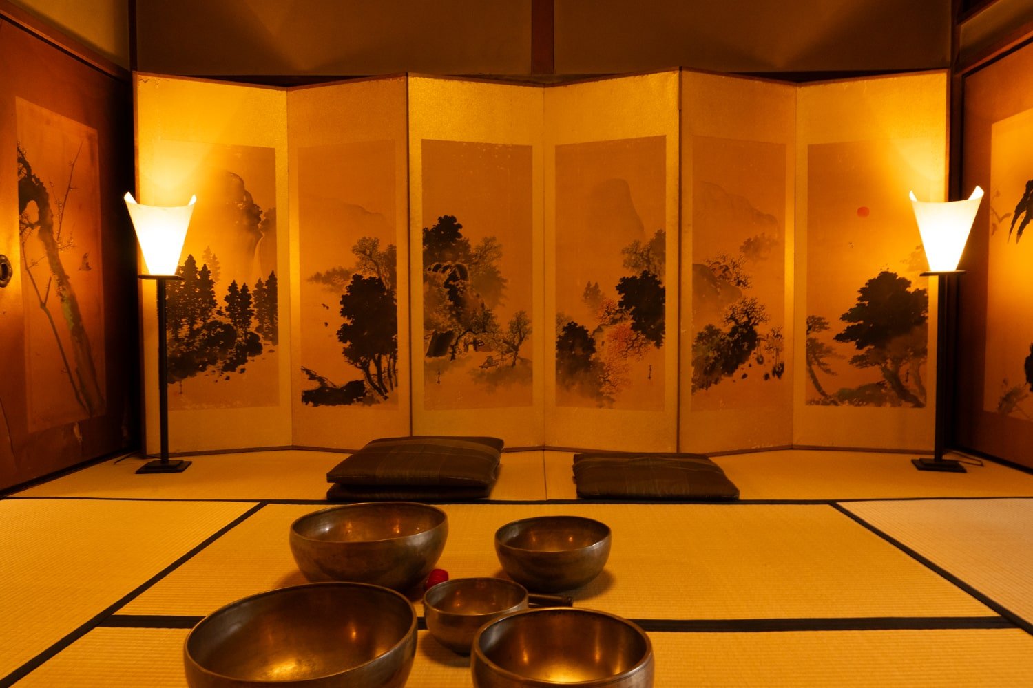 A historic Japanese tatami room with decorated panels and singing bowl for Zen meditation.