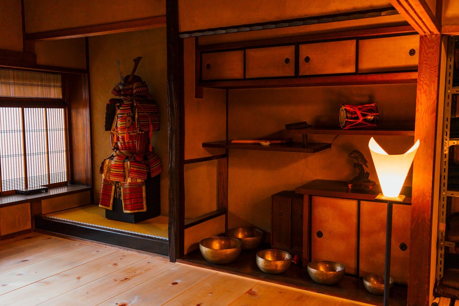 Traditional samurai armor and zen meditation bowls on display inside former samurai officer's historic townhouse in Kyoto, Japan.