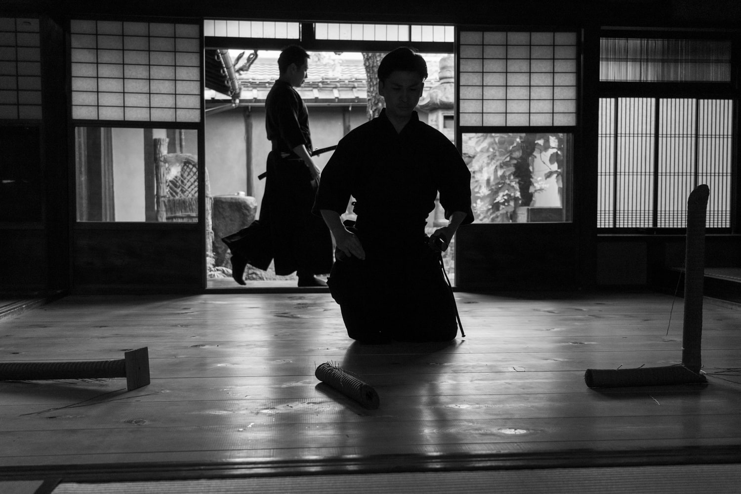 A black and white photo of a samurai katana demonstration inside a 250-year-old historic samurai's home.