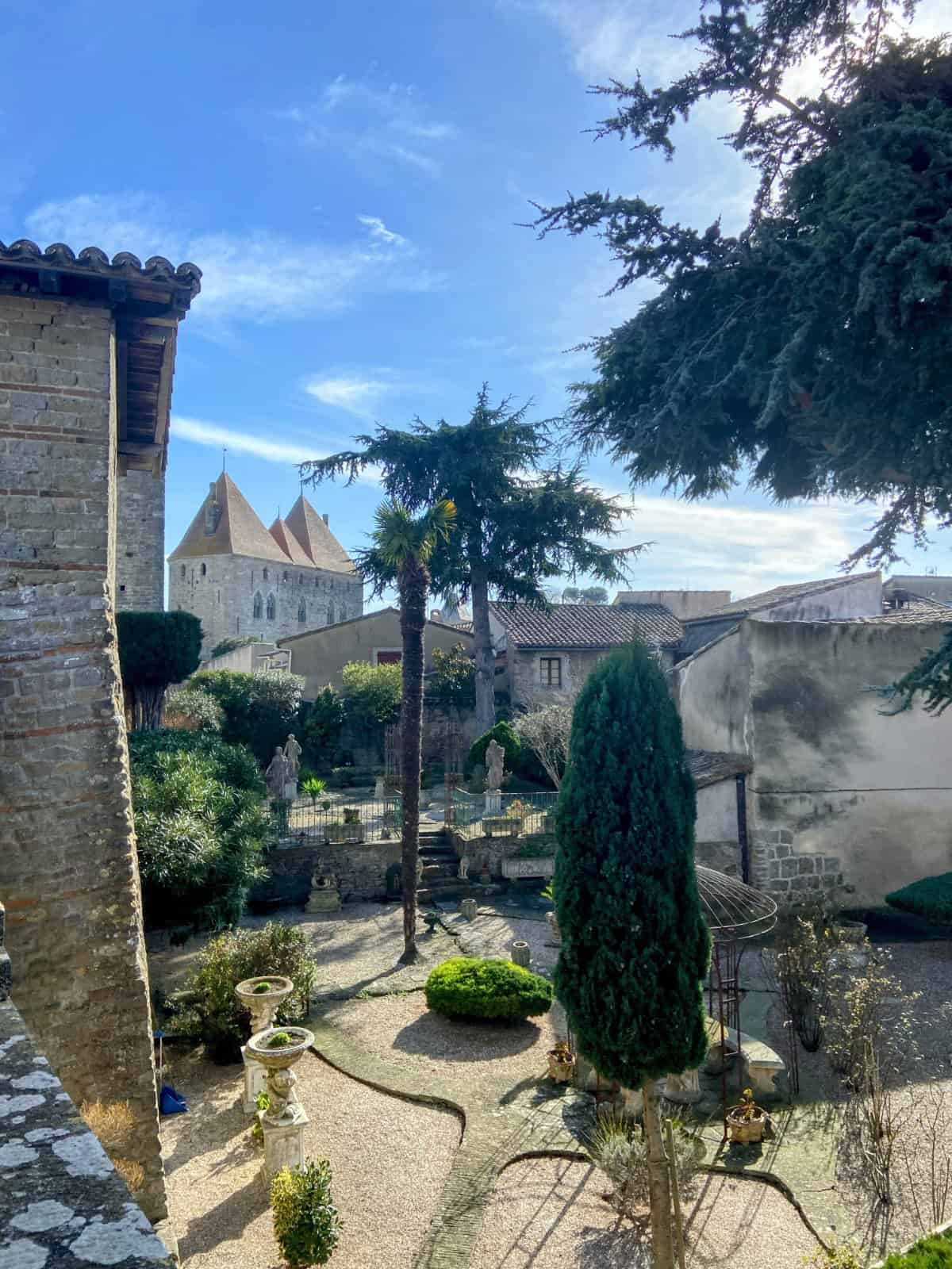 Shot of an inner courtyard of the Carcassonne Castle with landscaping, as seen from the ramparts