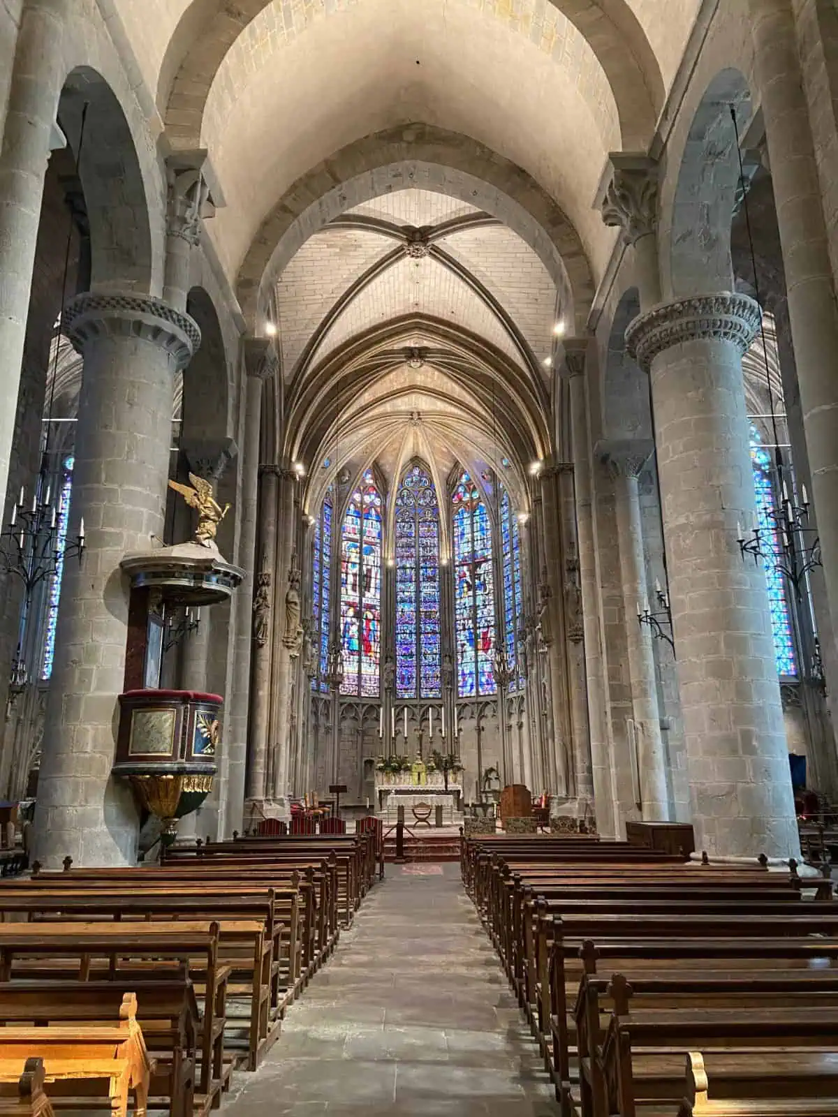 Inside Saint Nazaire Basilica in Carcassonne with the pews and stained glass windows