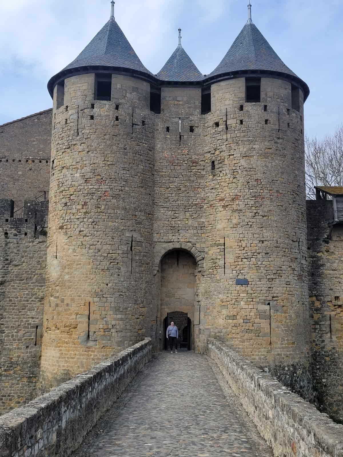 Riana standing in front of the castle doors in Carcassonne on a Toulouse to Carcassonne Day Trip