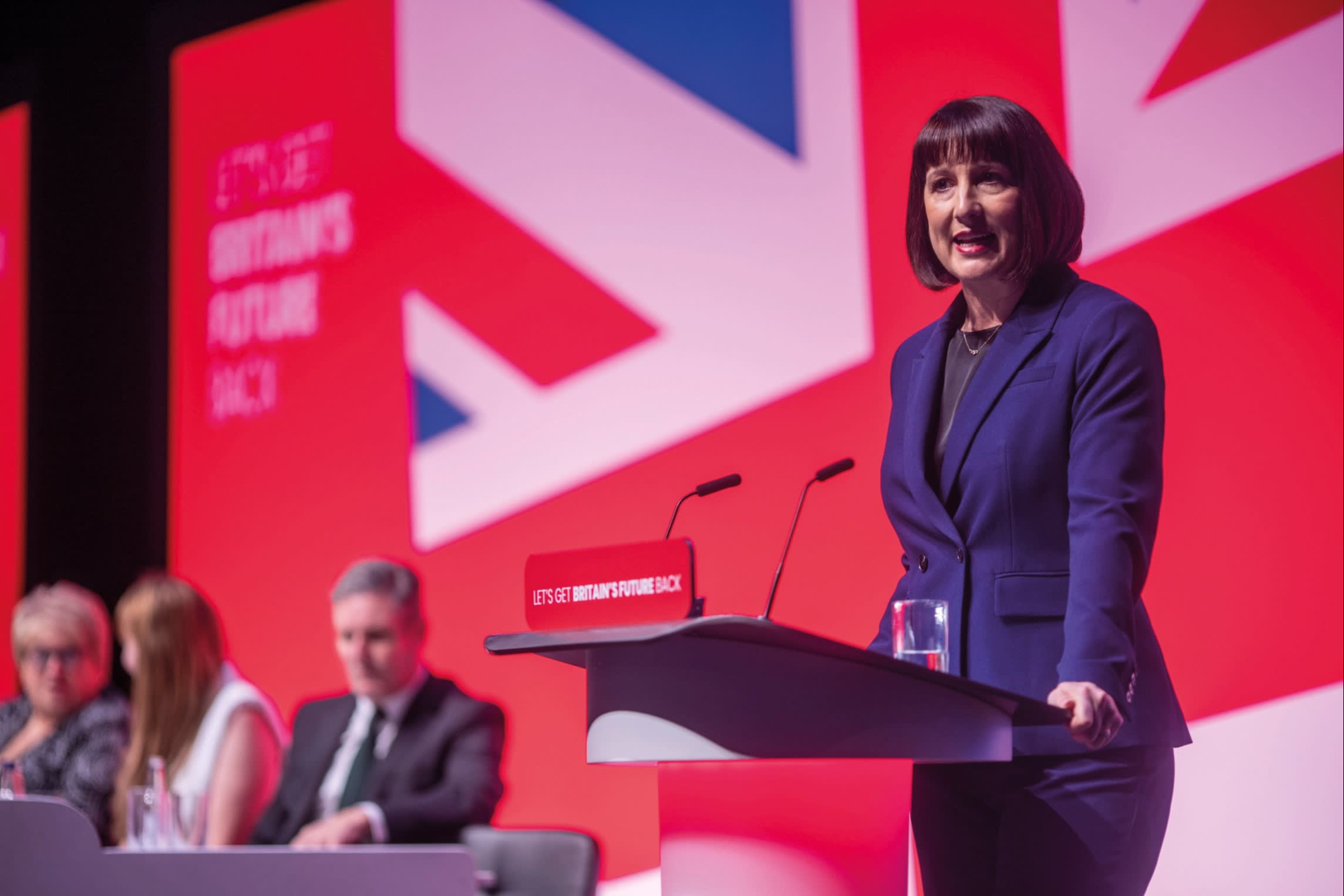 Rachel Reeves, Labour shadow chancellor, at the podium, speaking to a crowd