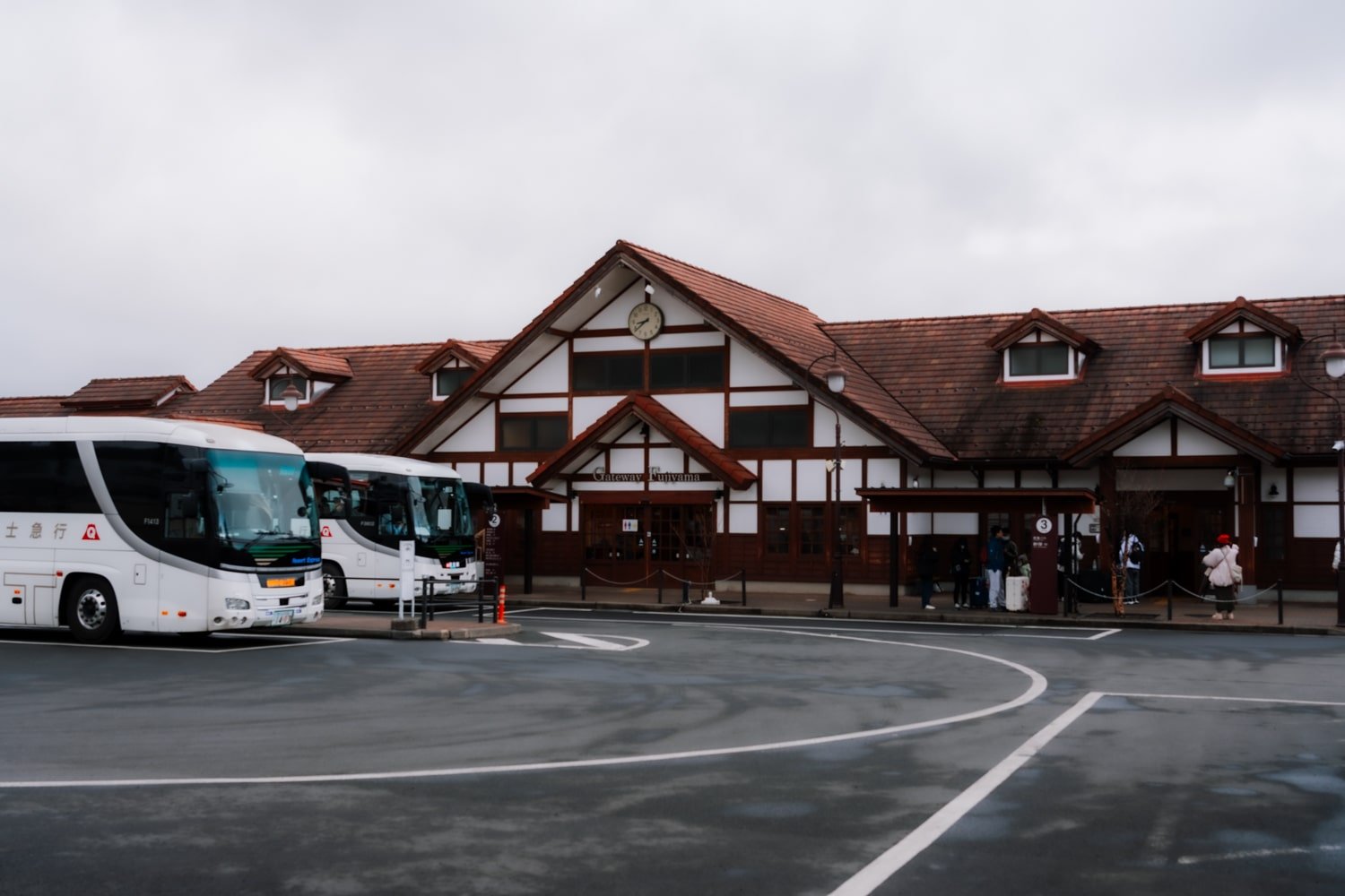 Buses and tourists at the Kawaguchiko Station main building.