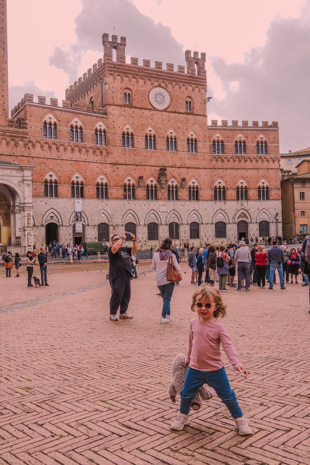 Family enjoying sunny day in Siena's historic Piazza del Campo