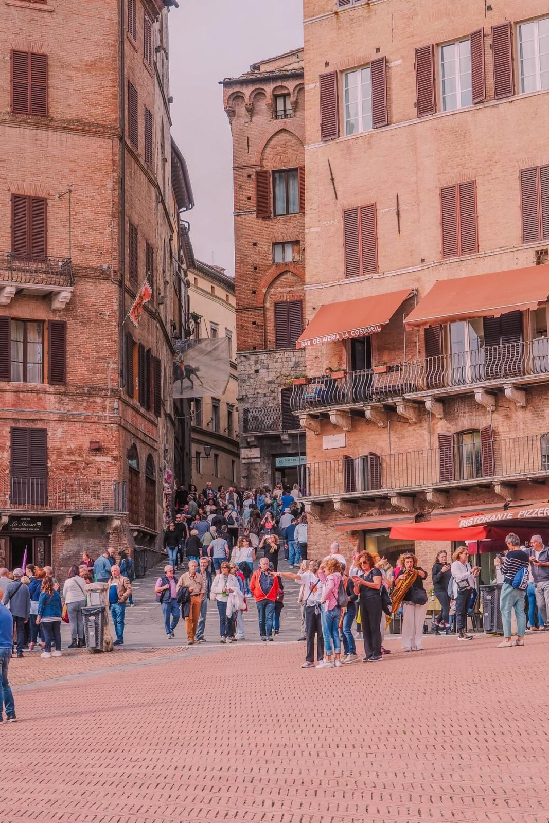 Bustling street scene in Siena, Italy with locals and tourists