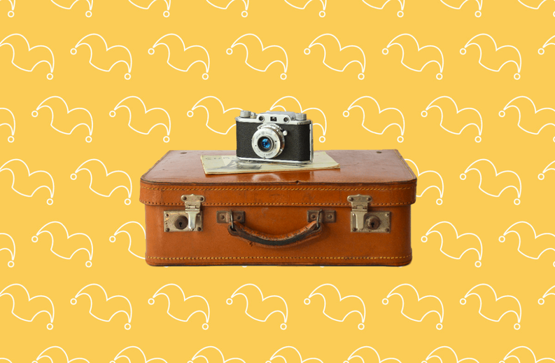 An old leather suitcase with a camera on top of it