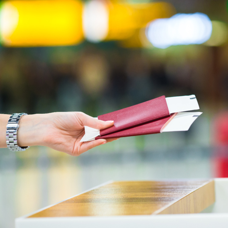 Tourists-hands-passports-over-immigration-counter-at-airport