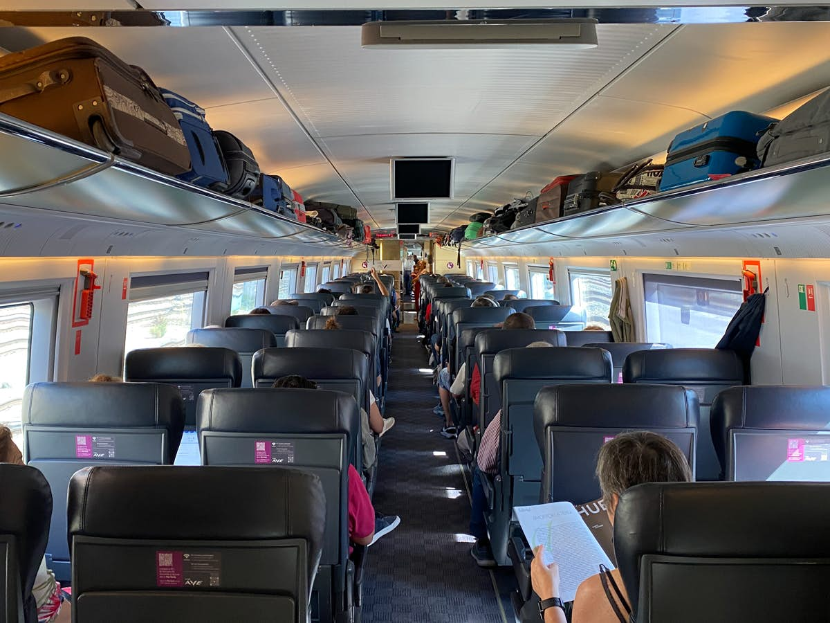 Onboard an AVE service from Madrid, passengers are seen sitting and reading