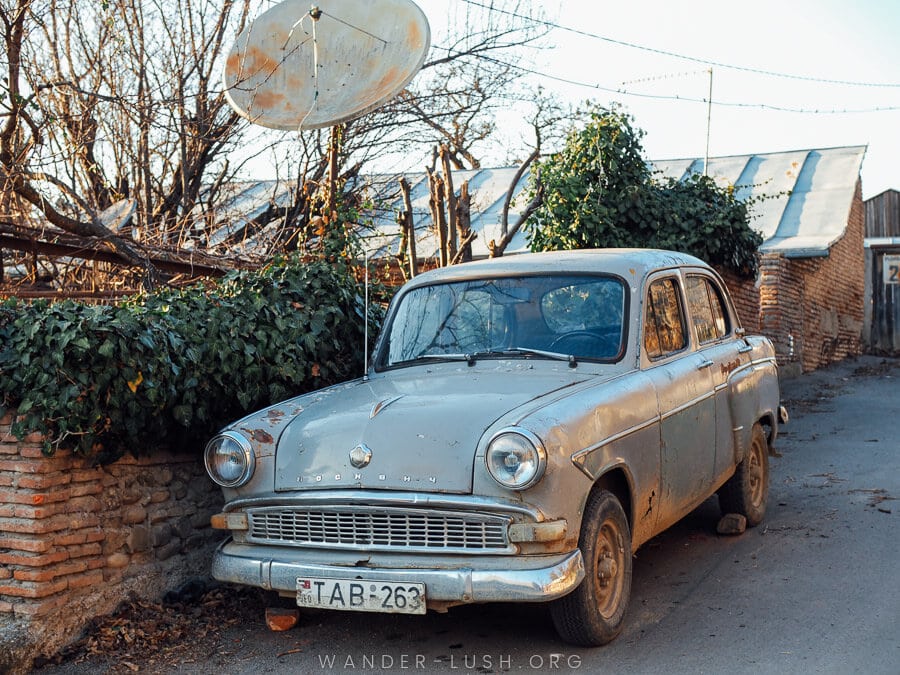 A vintage car parked on a suburban street in Sighnaghi.