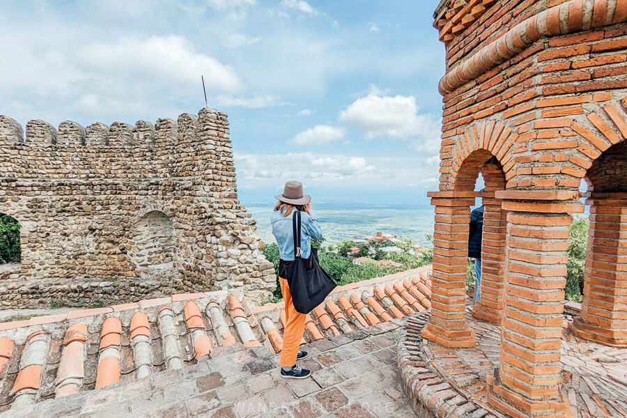 A woman on the roof of a church in Sighnaghi for a view of the Alazani Valley.
