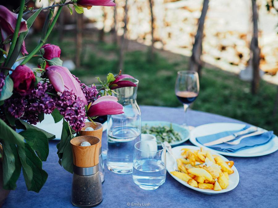 A table with a purple tablecloth and plates of food.