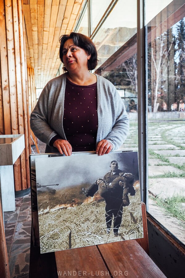 A woman holding a photo inside the war memorial in Gurjaani.
