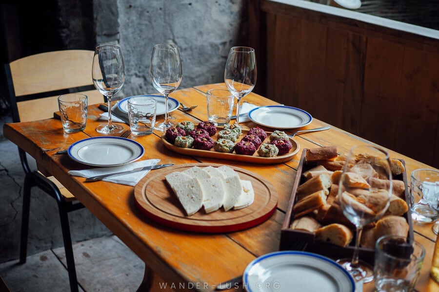 A wooden table laid out with wine and traditional Kakhetian food at a winery near Telavi.