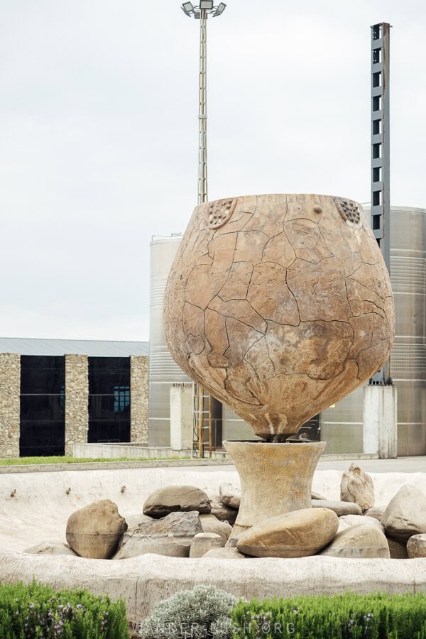 A reproduction of a historic wine making vessel standing in a winery in Georgia.