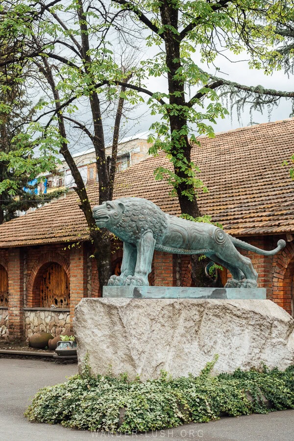 A tarnished lion sculpture standing at the entrance to the Bolero wine cellar in Kakheti.