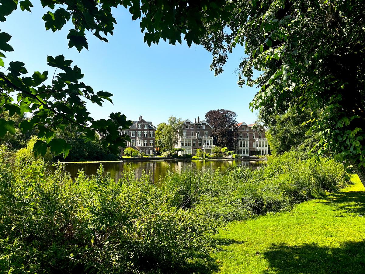 Vondelpark scenery with greenery, calm waters, and Dutch architecture