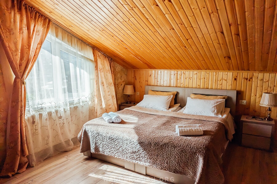 A comfortable guest room with wooden ceilings and floors at Guest House Tamta in Kazbegi, Georgia.