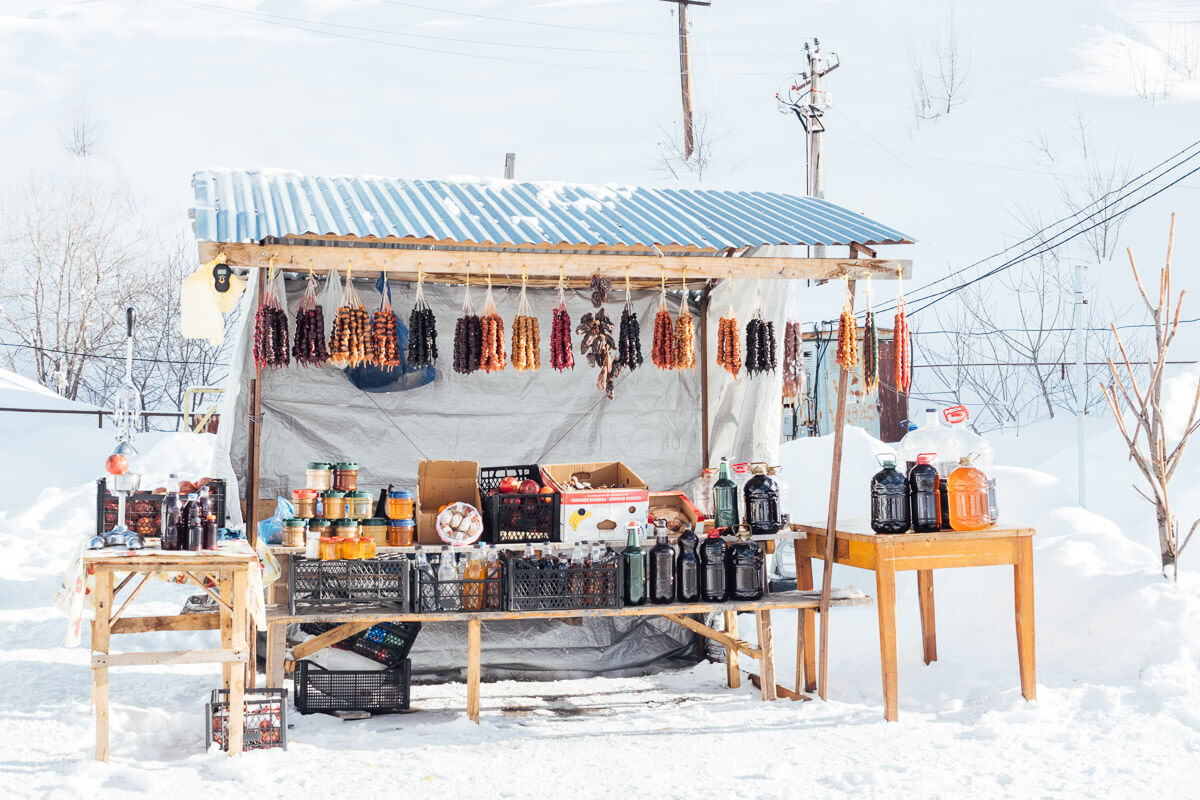 A roadside stall selling churchkhela, wine and other traditional Georgian products in the snow in Gudauri.