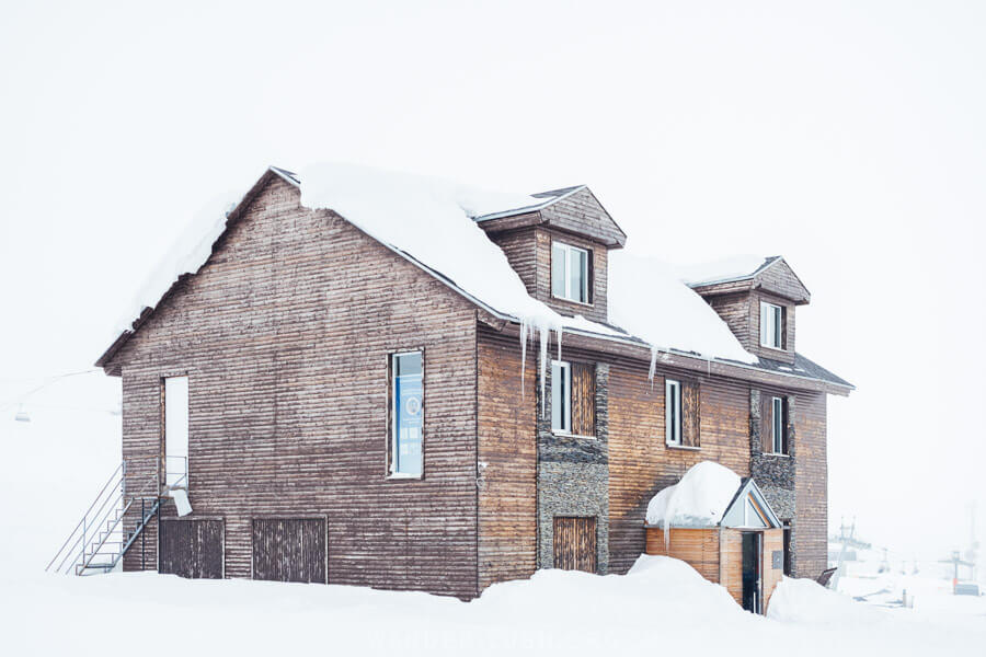 A cute wood cabin with a snowy roof in Gudauri, Georgia.