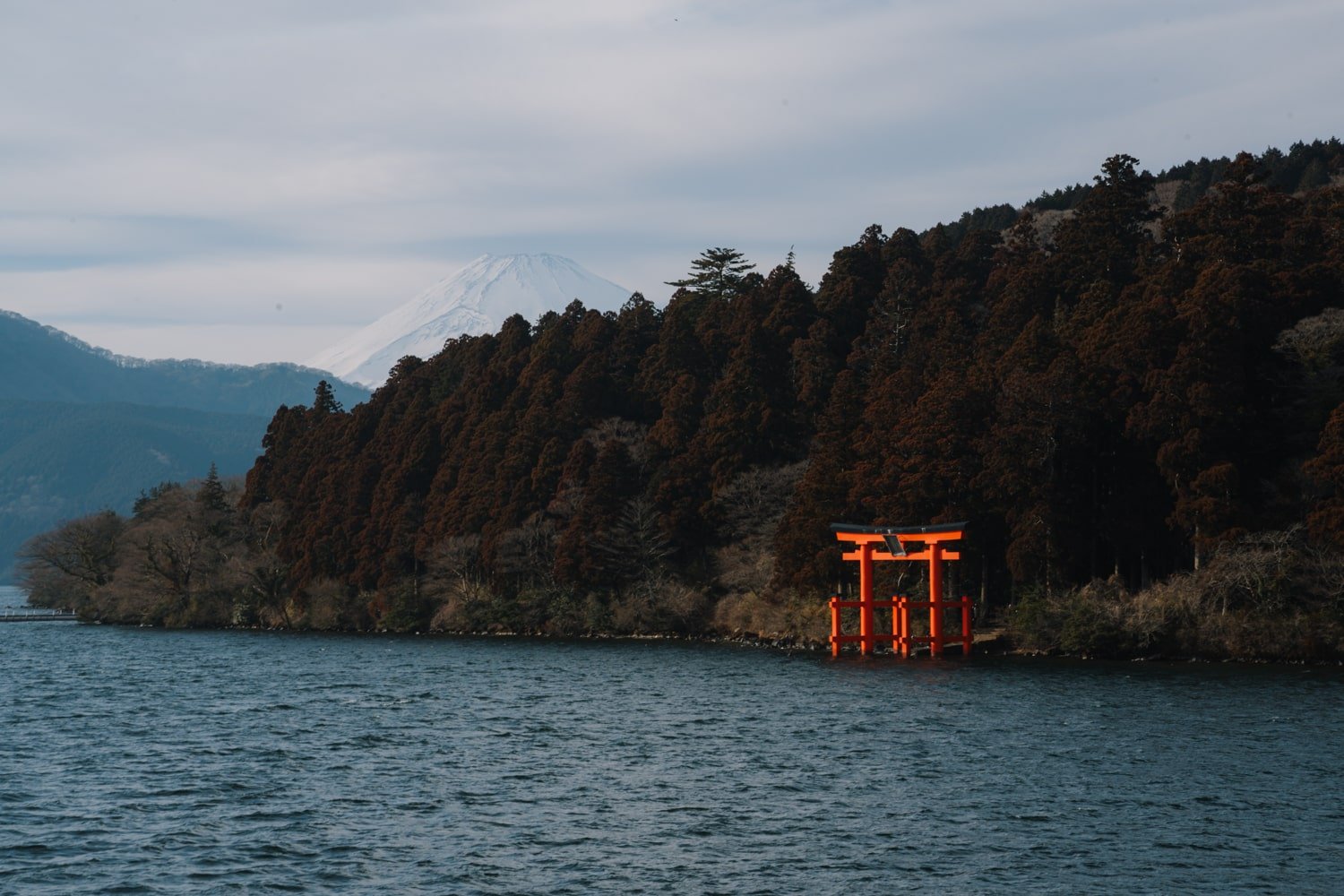 Hakone Shrine Torii gate in Lake Ashinoko with Mount Fuji in the background.