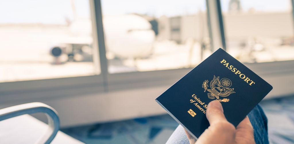 USA passport, waiting for flight in boarding lounge with aeroplane in background