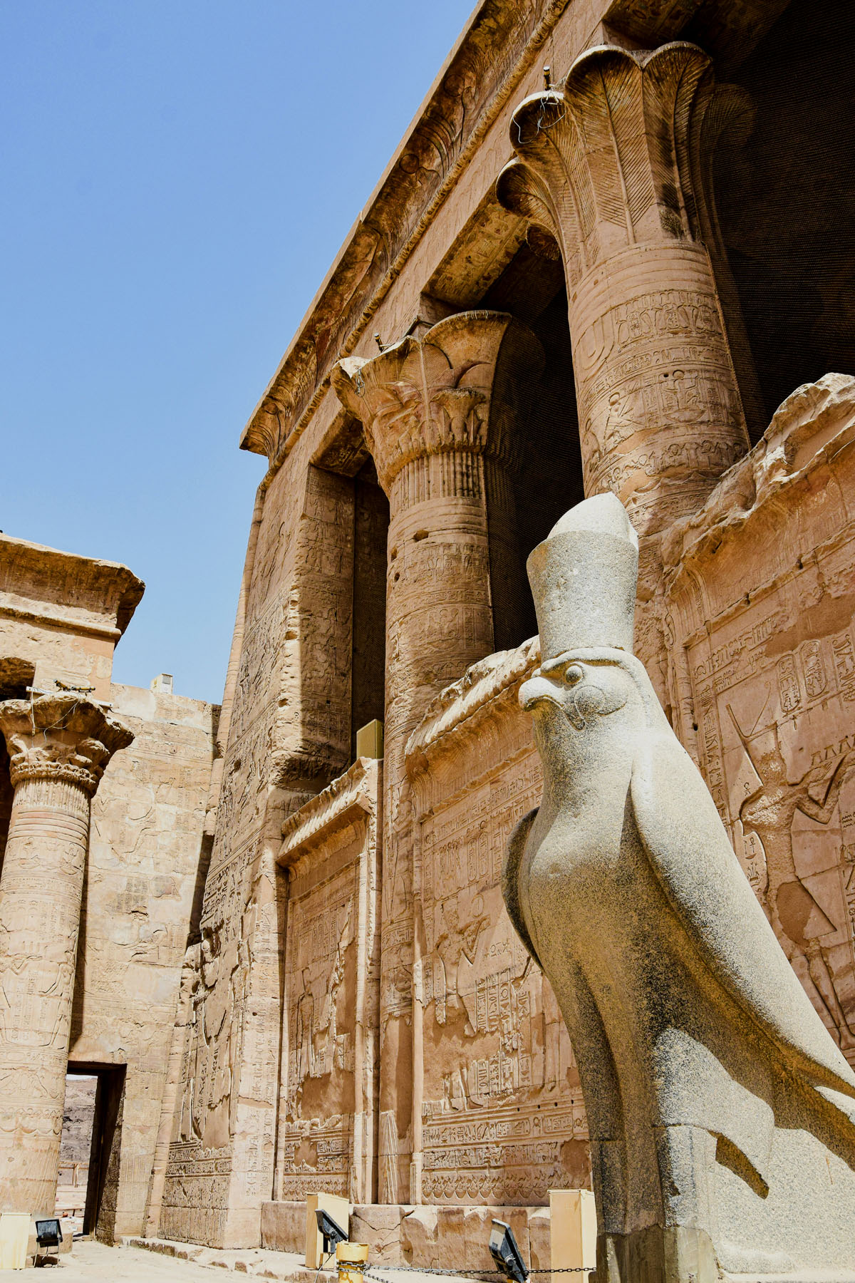 A statue of the falcon god Horus stands at the entrance of the Edfu Temple in Egypt. 