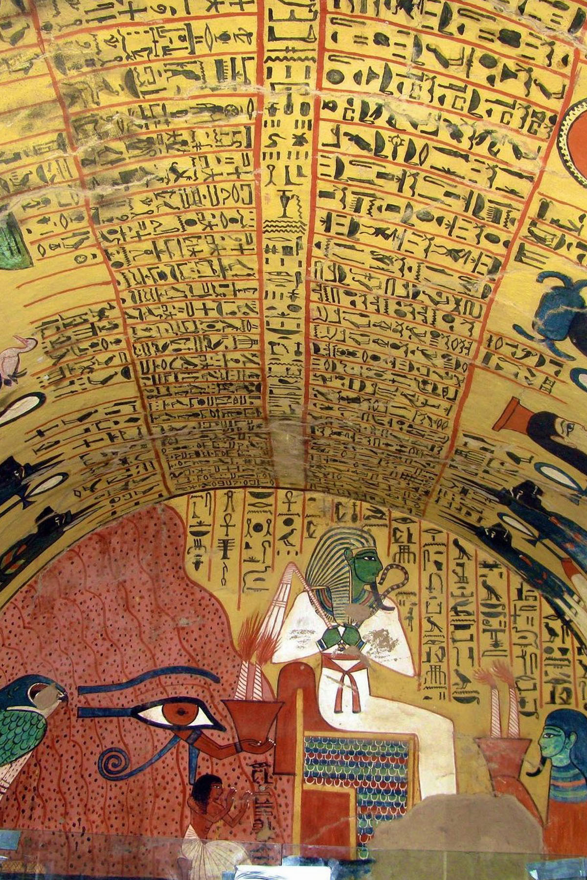 A colorful tomb inside Deir el Medina in Luxor is colored in hieroglyphs and yellows that depict Egyptian gods. 