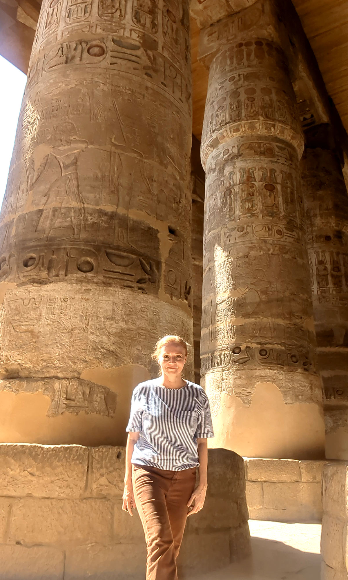 Dee walks between enormous columns inside the hypostyle hall at Karnak Temple in Luxor. 