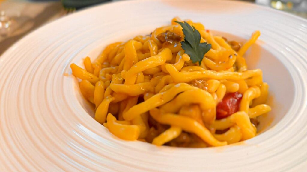 Savor authentic Italian Picci pasta dish at Trattoria da Fiorella - freshly made pasta with rich sauce on a ceramic plate