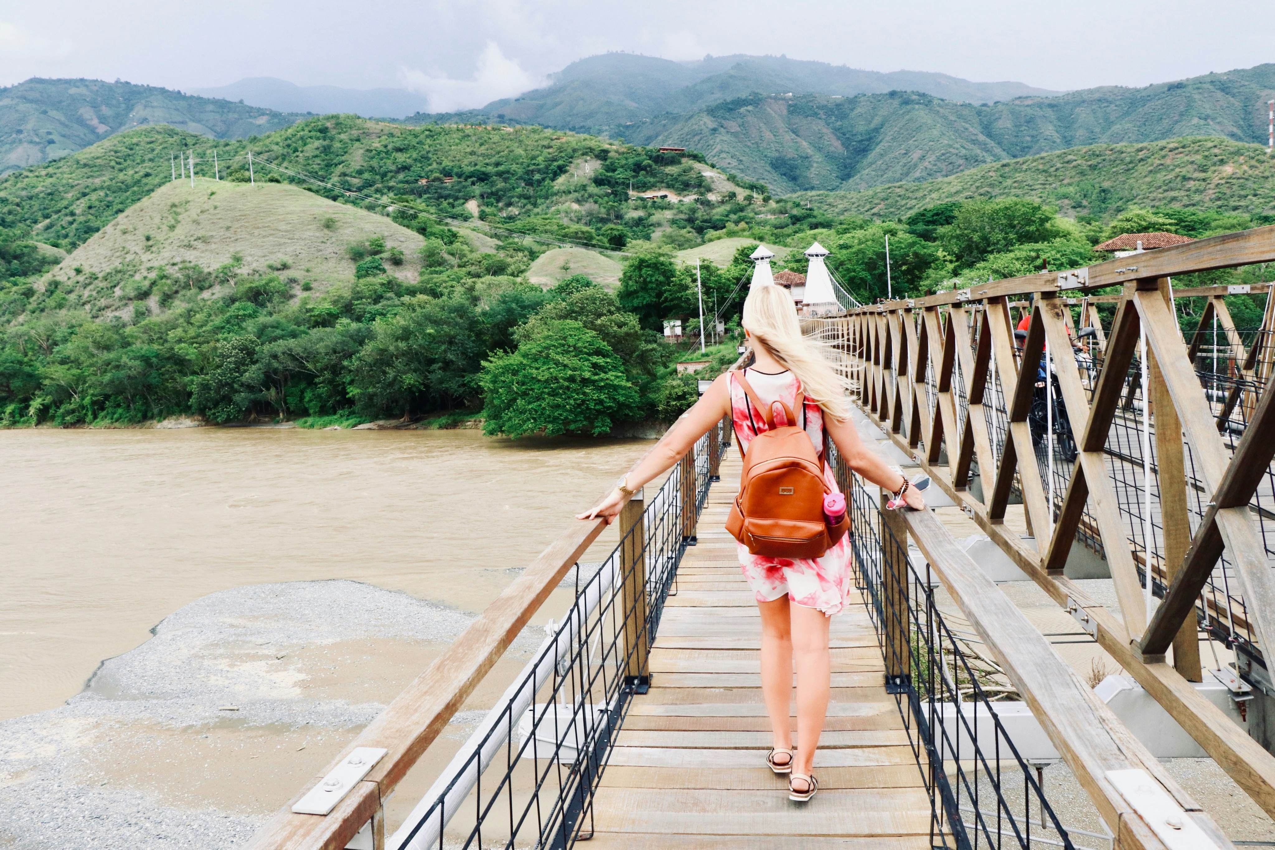 Woman walks across a bridge in the wind in Medellín, Colombia