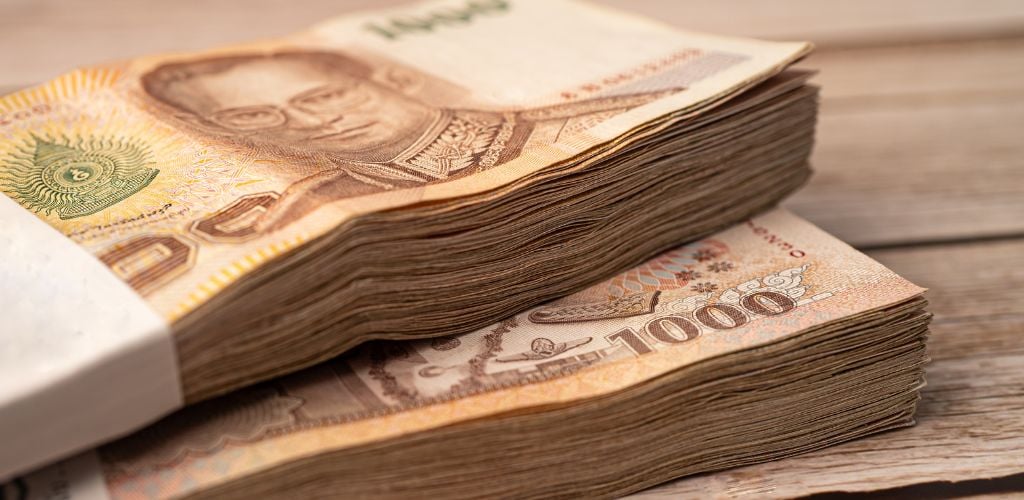 Stack of Thai Baht on a wooden table 